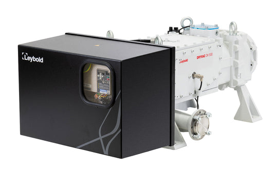 Image of a Leybold DRYVAC DV 500 vacuum pump. The pump has a black rectangular casing with an observation window, showing internal components. On the right side, a metallic chassis and plumbing connections for the vacuum system are visible. The Leybold logo is on the casing.