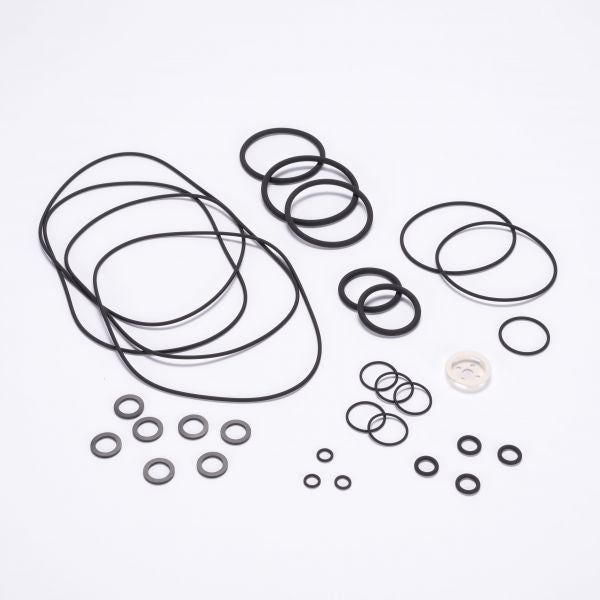 The Seal Kit RUVAC WS/WSU 151-251 - BR2 by Leybold North America, featuring a variety of black rubber O-rings and metal washers of different sizes, is spread out on a white surface. The kit includes both large and small rings, with a total of approximately twenty-eight pieces.