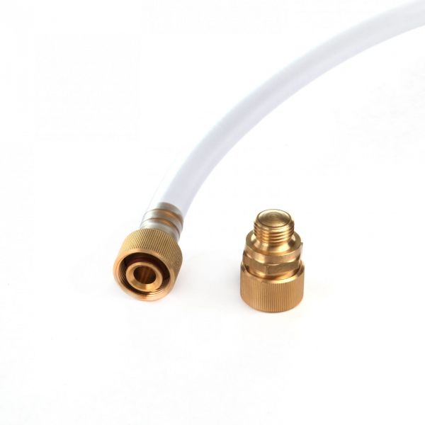 A close-up of the Leybold North America Oil Drain Unit M16 x 1.5 brass connector attached to a white flexible hose, with a separate brass fitting placed nearby on a plain white background—a perfect setup for efficient oil changes.