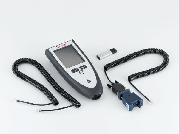 The Leybold North America Remote Control RC 310 C, Wired, includes a display screen and two buttons reminiscent of a controller. It’s connected by two coiled black cables to a small blue attachment and silver cylindrical part, all arranged on a light background, ensuring stable performance.