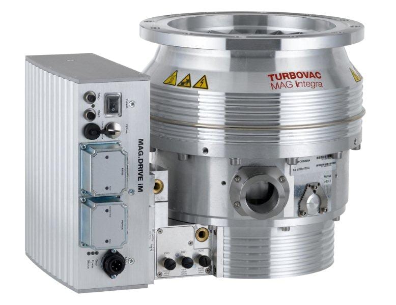 A high-performance vacuum pump, labeled as "TURBOVAC MAG W 1300 iP" from Leybold North America Shop, features a robust metallic construction with various ports and connectors. Ideal for high-vacuum pumping systems, the pump has an attached electronic control unit and displays warning symbols indicating caution.