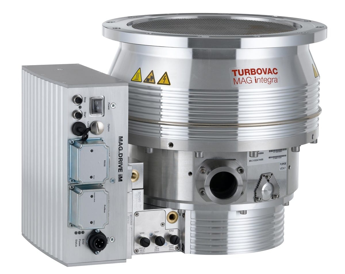 This image shows a MAG W 2200 iP, 24 V SPS interface, a high-vacuum turbomolecular pump from Leybold North America Shop. It has a metallic cylindrical body with various ports, connectors, and warning signs. An attached control unit labeled "MAG DRIVE IM" is visible on the side.
