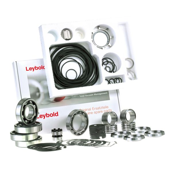 On a table, there is an assortment of metal and rubber components such as rings, gaskets, and bearings. In the background, packaging with the brand name "Leybold North America" is visible, indicating that these vacuum pump spare parts might be from the Major Maintenance Kit RUVAC WS 2001.
