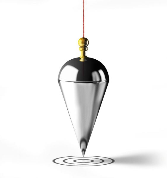 A DAkkS- / DKD-calibration pressure device, from Leybold North America, featuring a shiny, silver plumb bob with a gold attachment is suspended by a red string against a white background. The pointed end of the plumb bob is aligned with a target symbol on the ground below it.