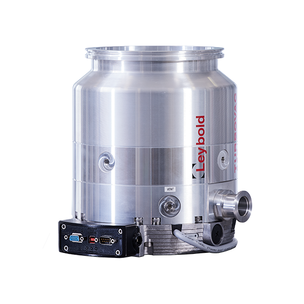 A cylindrical metallic Leybold North America Shop TURBOVAC 850i vacuum pump with a wide opening at the top. It features a ridged base and multiple connection ports. A smaller black box with various connectors is attached to its base. The device is placed on a textured surface.