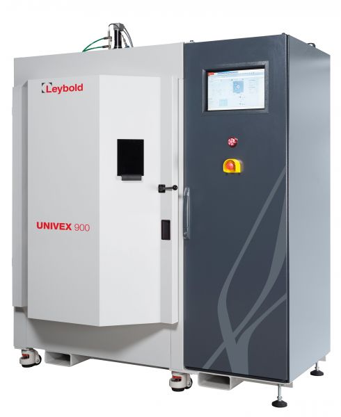 The Leybold North America HV-experimentation system UNIVEX 900 is a vacuum coating unit characterized by its large gray and white rectangular body, featuring a black square window on the front. It is equipped with a digital control panel that includes a touchscreen display and several buttons, one of which is a prominent red emergency stop button.