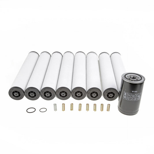 The image displays seven horizontally arranged cylindrical white filters alongside a vertically standing gray cylindrical filter. In front of the filters, small essential replacement parts, such as springs and rubber rings from the Leybold North America Service Kit SV 630 B, are carefully arranged.