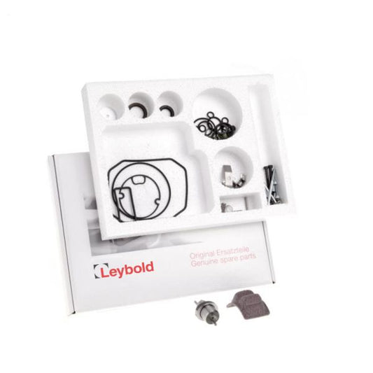 A Leybold North America Complete Repair Kit Trivac D 2,5 E2 containing various spare parts is open. The packaging foam displays multiple compartments holding items like gaskets, O-rings, screws, and other small mechanical components. The Leybold North America logo is visible on the box lid in the background.
