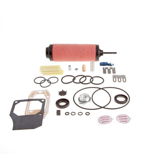 A set of Leybold Repair Kit SOGEVAC SV 25 B components laid out on a white background. The set includes a red cylindrical filter, various rubber O-rings, gaskets, springs, metal clips, a threaded cap, and other small parts.