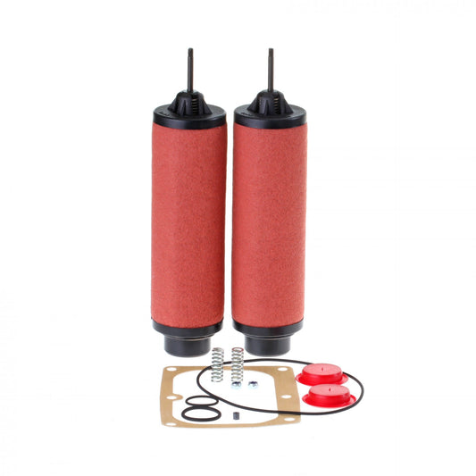 The image shows two cylindrical air filters with red filter material and black ends placed vertically side by side. Below them, there are two red caps, springs, and a gasket set, including O-rings and a cardboard-like gasket. All parts of the Leybold Service Kit SOGEVAC SV 100 B / SV 120 B are neatly arranged.